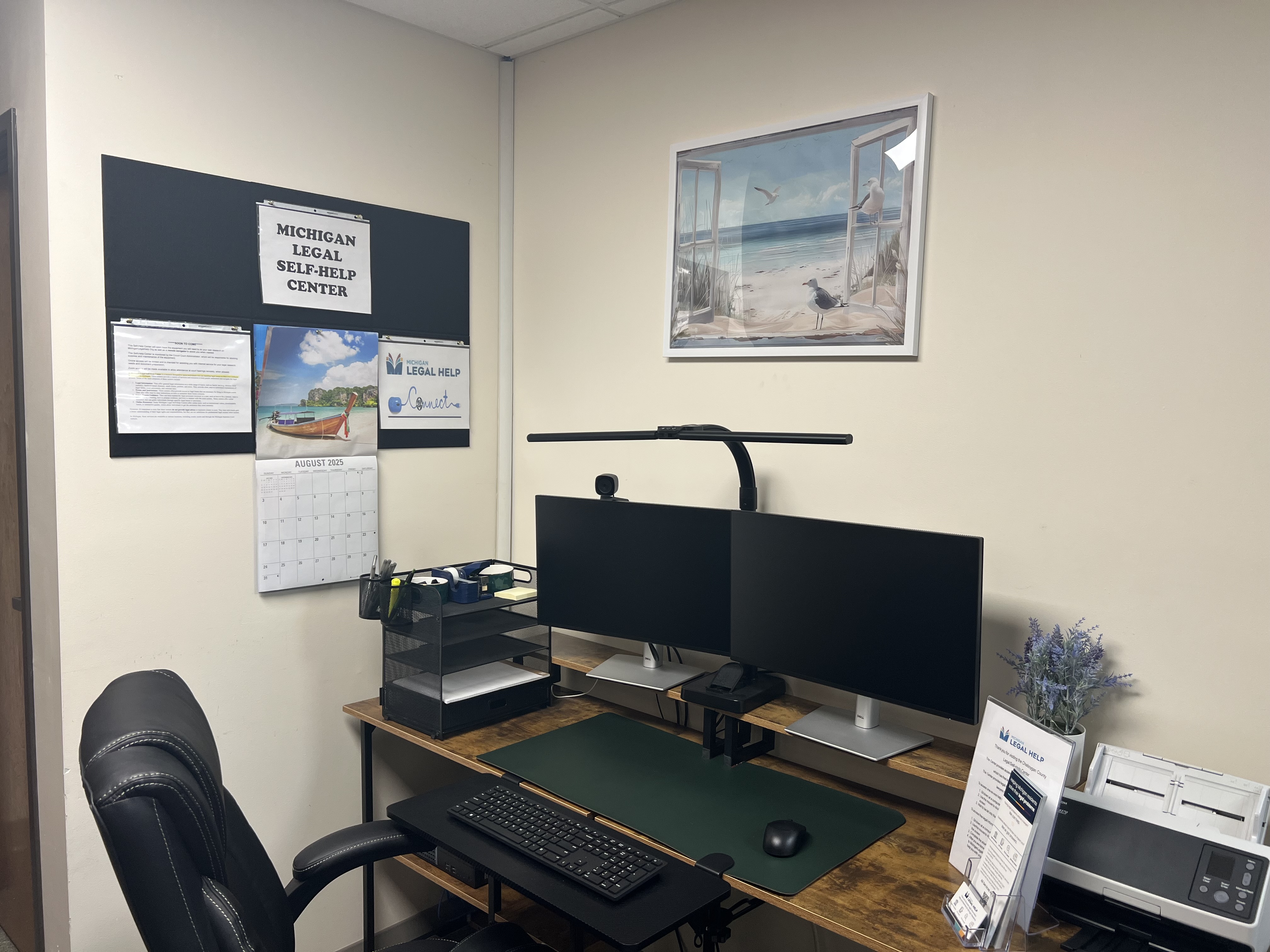 Inside of a Legal Self-Help Center showing a double monitor, comfortable chair, and printer 