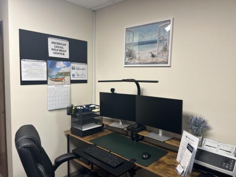 Inside of a Legal Self-Help Center showing a double monitor, comfortable chair, and printer